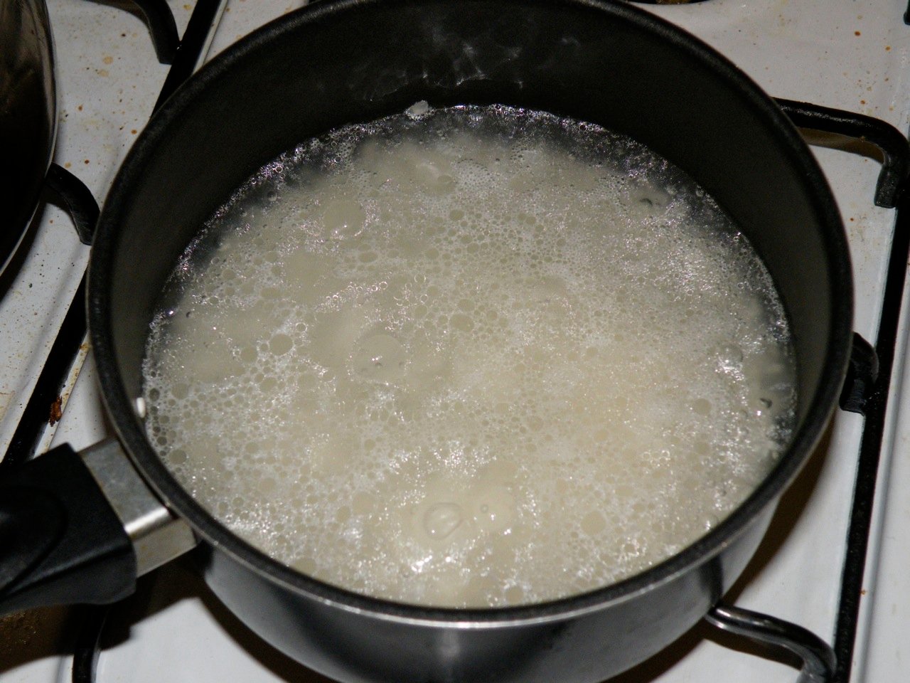 Arroz blanco cociéndose en una olla con agua
